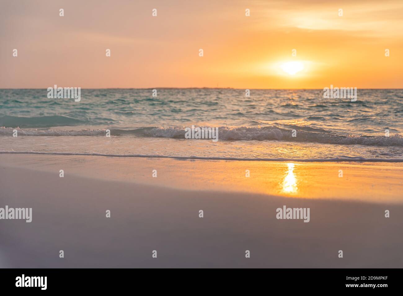 Weicher Sand, ruhige Meereswellen an der tropischen Küste, Meer unter bunt bewölktem Himmel. Atemberaubende Sonnenuntergangs-Strandlandschaft, Zen-Paradies, ruhige Insel Stockfoto