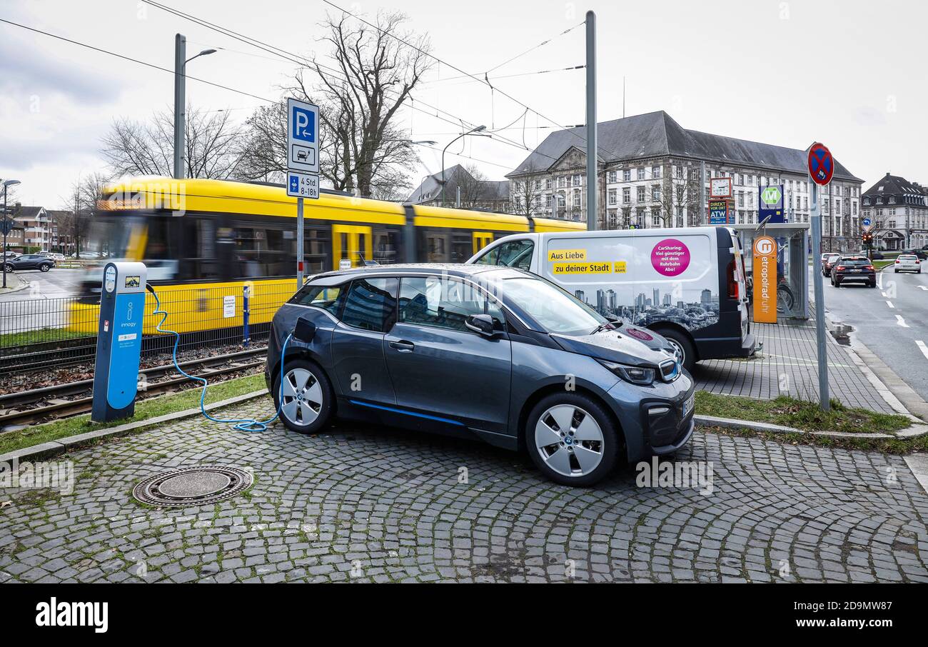 Elektroauto steht an der Mobilstation Landgericht an einer Ladestation, hinter einer Straßenbahn, Essen, Ruhrgebiet, Nordrhein-Westfalen, Deutschland Stockfoto