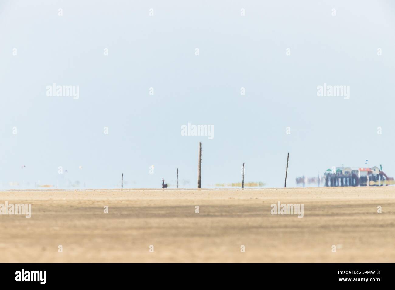 FATA Morgana am Wattenmeer - schimmerndes Licht - Blick über den Strand auf das Wattenmeer und Stelzenhäuser. Stockfoto