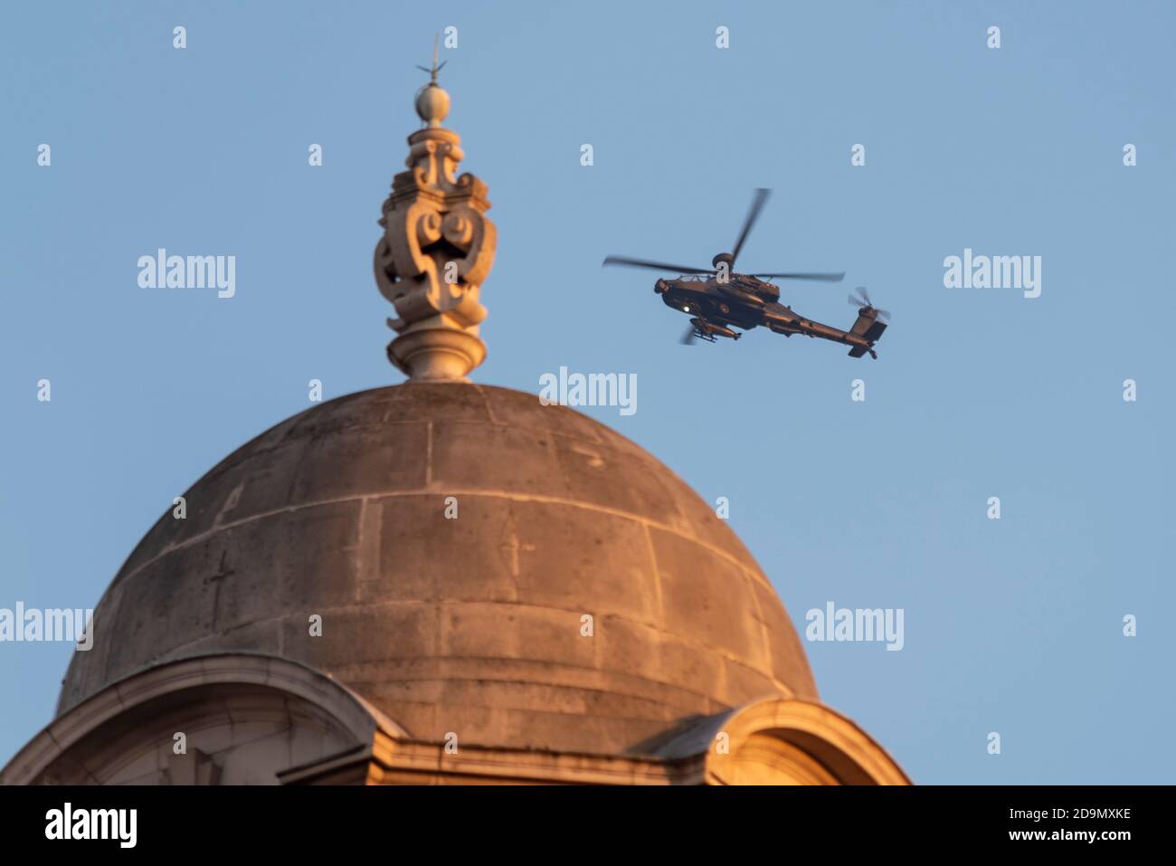 British Army AH-64 Apache Gunship Hubschrauber fliegen über historische Old war Office Gebäude in Westminster, London, UK, am späten Nachmittag warmes Licht Stockfoto