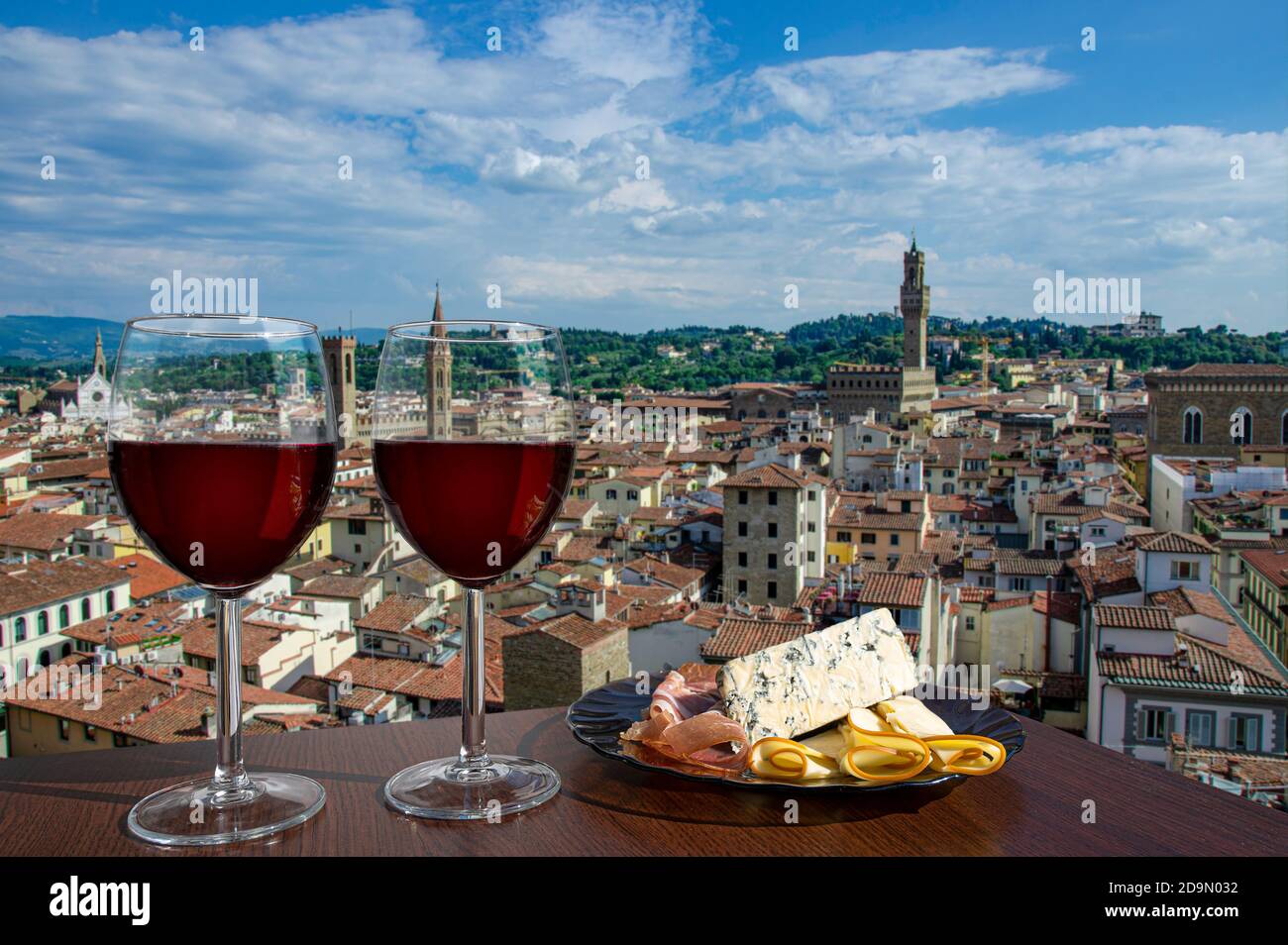 Zwei Gläser Wein mit Käse und Fleisch Snacks mit Blick von oben auf das historische Stadtzentrum von Florenz in Italien. Ein Glas Rotwein mit verschiedenen Snacks Stockfoto