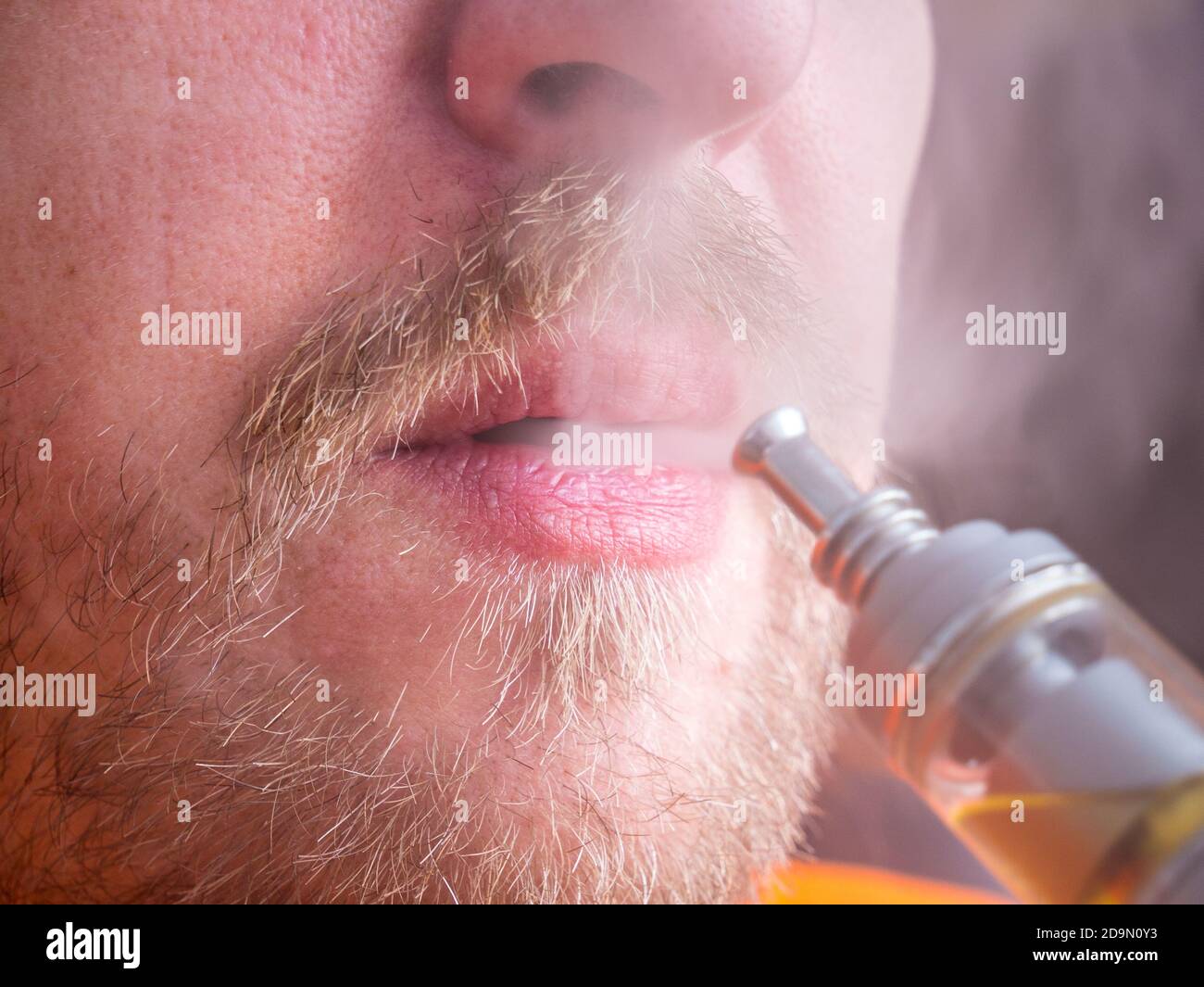 Nahaufnahme des Mundes mit Schnurrbart mit elektronischer Zigarette und Ausatmen Dampf Stockfoto