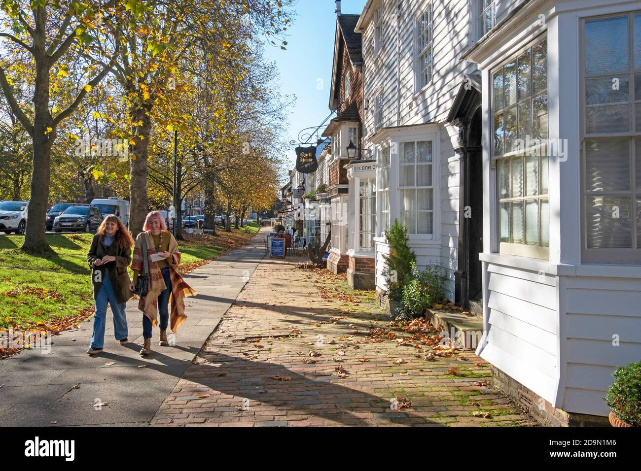 Geschäfte und Cafés auf dem breiten Bürgersteig von Tenterden High Street, Kent, Großbritannien Stockfoto