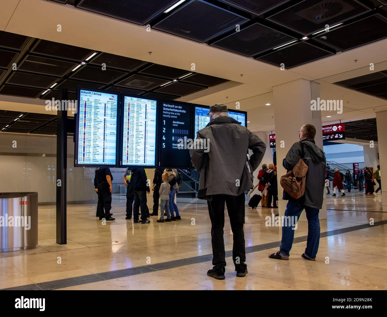 Schönefeld, 1. November 2020 - Passagiere am Flughafen Berlin Brandenburg (BER) stehen vor der Informationstafel Stockfoto