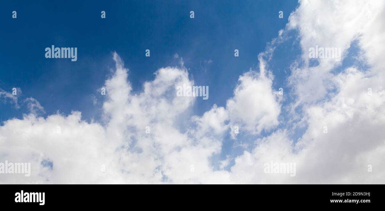 Tiefblauer Himmel mit Kumuluswolken am Tag. Natürliche Fototextur im Hintergrund Stockfoto