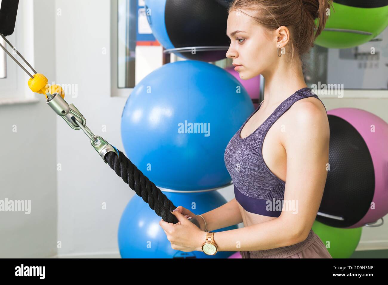 Junge europäische blonde sportliche Mädchen tut eine Übung in einem Fitnessraum Stockfoto