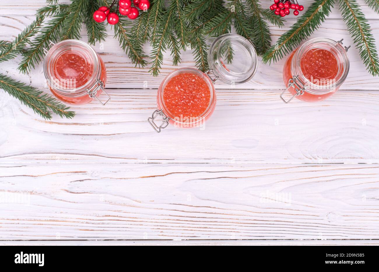 Baumkrug mit rotem Kaviar auf gealtertem weißem Holzhintergrund. Hauptgericht Neujahr Stockfoto