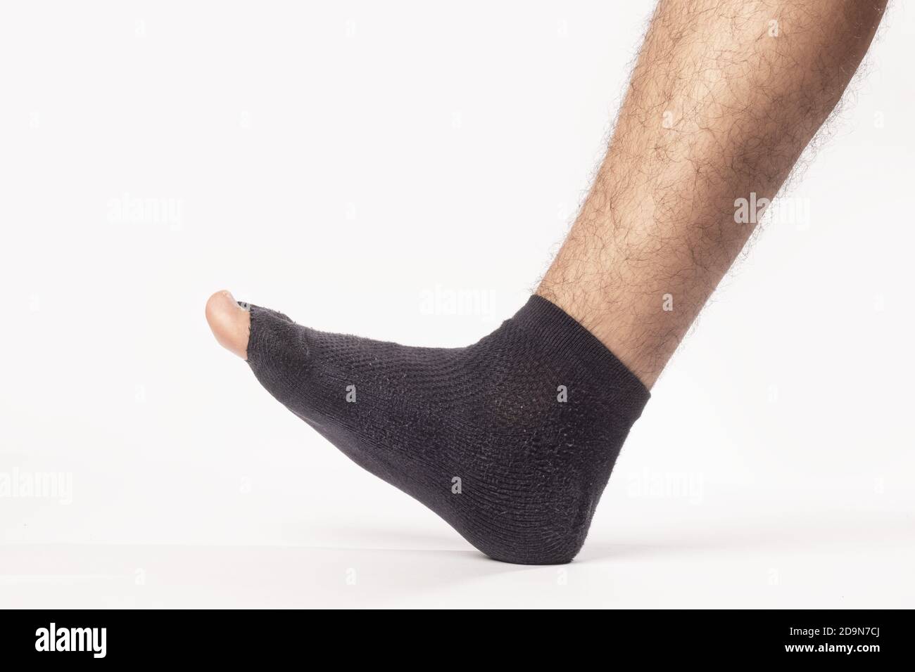 Nahaufnahme des Beins eines Mannes, der eine Socke trägt Mit einem Loch isoliert auf weißem Hintergrund Stockfoto