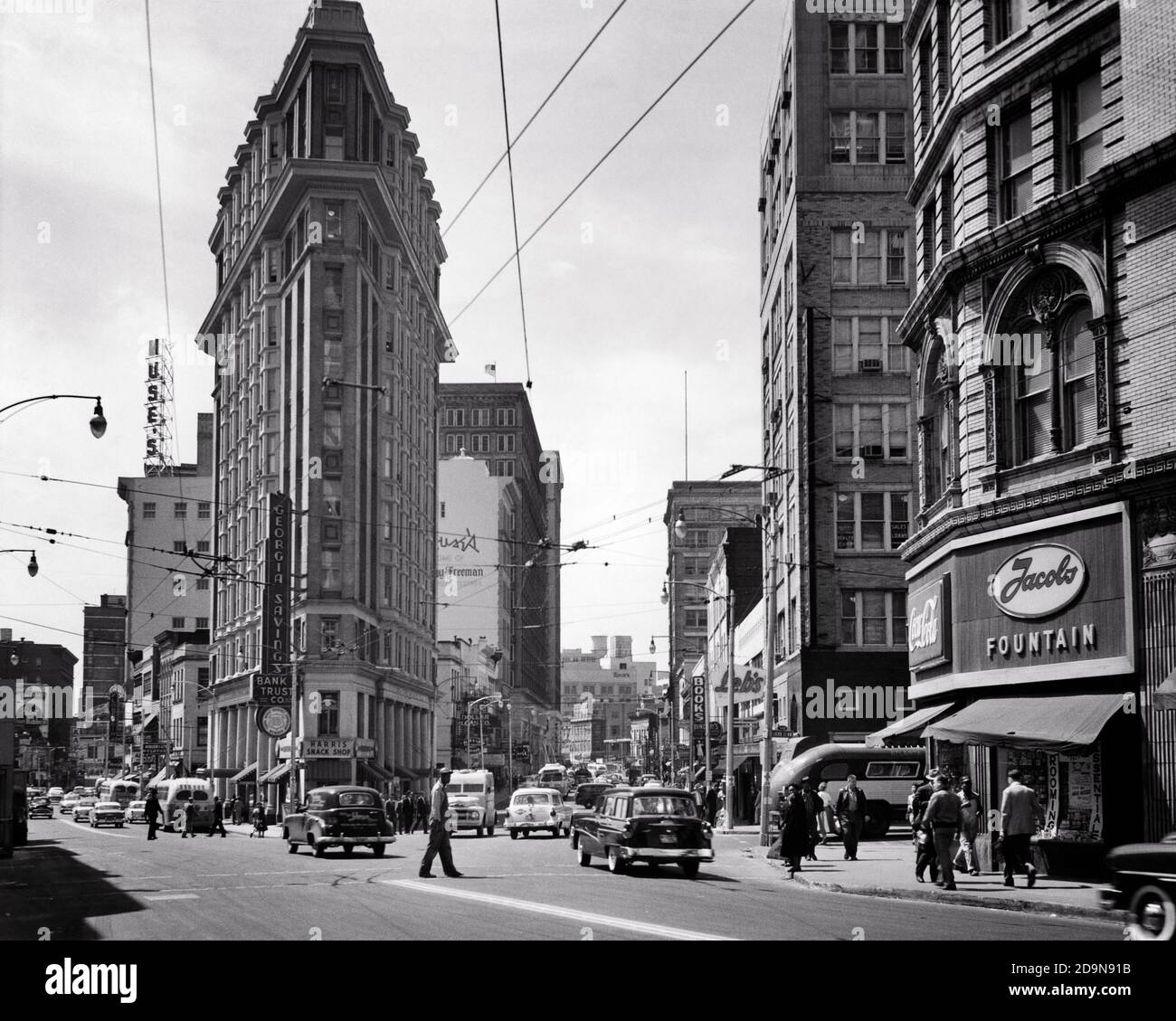 1950ER DIE ENGLISCH-AMERIKANER ODER FLATIRON GEBÄUDE AUTOS FUSSGÄNGER AUF BREITE UND PEACHTREE STRASSENKREUZUNG ATLANTA GEORGIA USA - Q75036 CPC001 HARS EIGENSCHAFT KRAFTFAHRZEUG UND AUTOS AUSSEN NIEDRIGEN WINKEL BREIT BEI DEN IMMOBILIEN-STRUKTUREN AUTOMOBILE FAHRZEUGE GEBÄUDE FLATIRON ODER BUSSE STREET SCENE TRANSIT 1897 SCHWARZ-WEISS GA MOTOR DIE FAHRZEUGE SIND ALTMODISCH Stockfoto