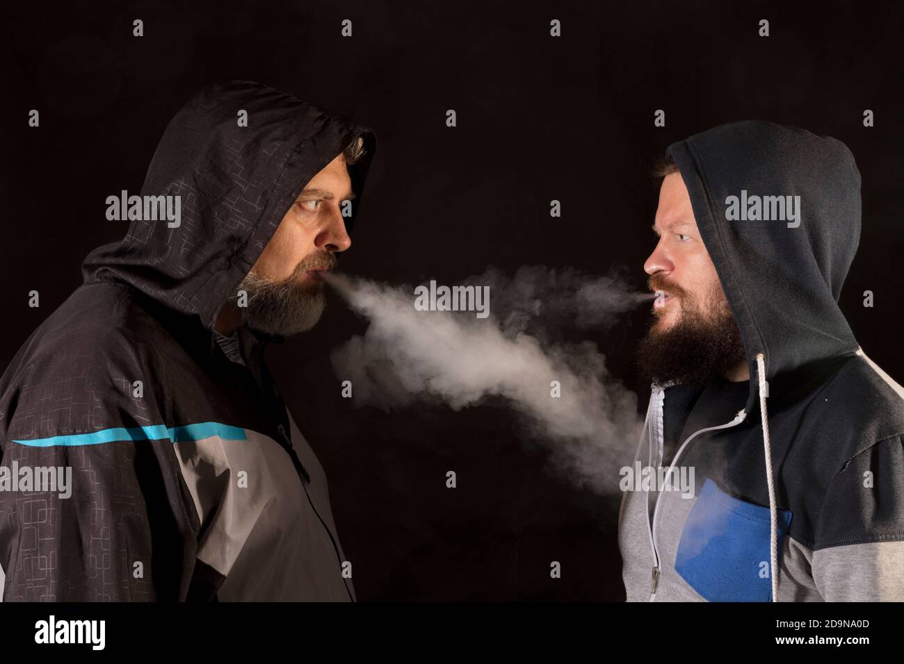 Zwei bärtige Mann in legerer Kleidung Ausatmen Dampf Studio Porträt Stockfoto