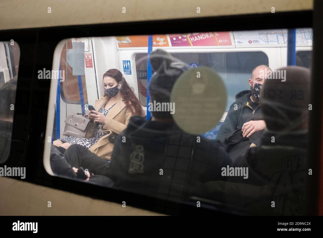 Pendler in der Londoner U-Bahn tragen Gesichtsmasken während der zweiten Lockdown, London, England Stockfoto