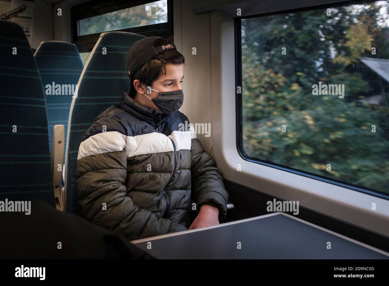 6. November 2020 , London, UK- Teenager Junge trägt Gesichtsmaske in öffentlichen Verkehrsmitteln, Südzug während der zweiten Lockdown. Stockfoto