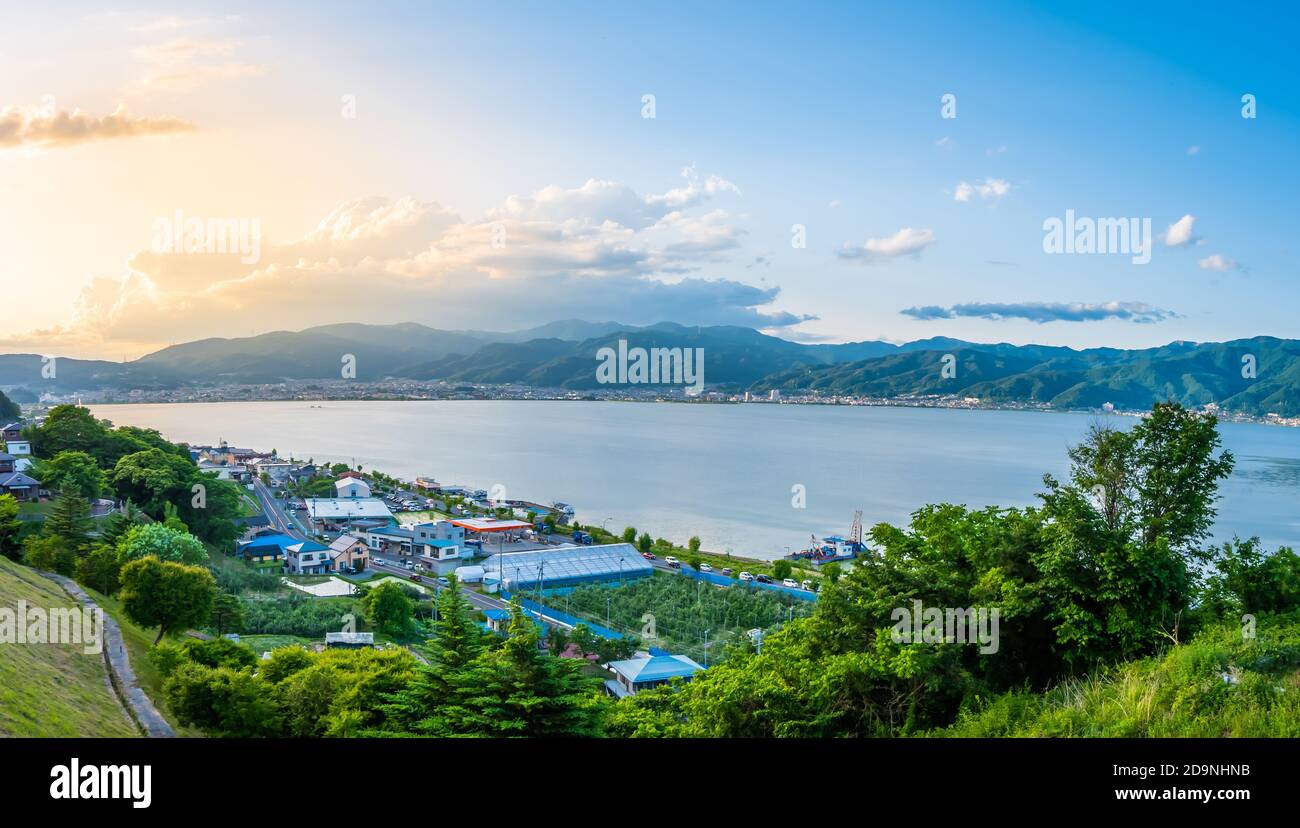 Suwa See in Nagano, Japan in der Sonnenuntergangszeit mit Stadt und Berg Hintergrund. Foto im Querformat Stockfoto