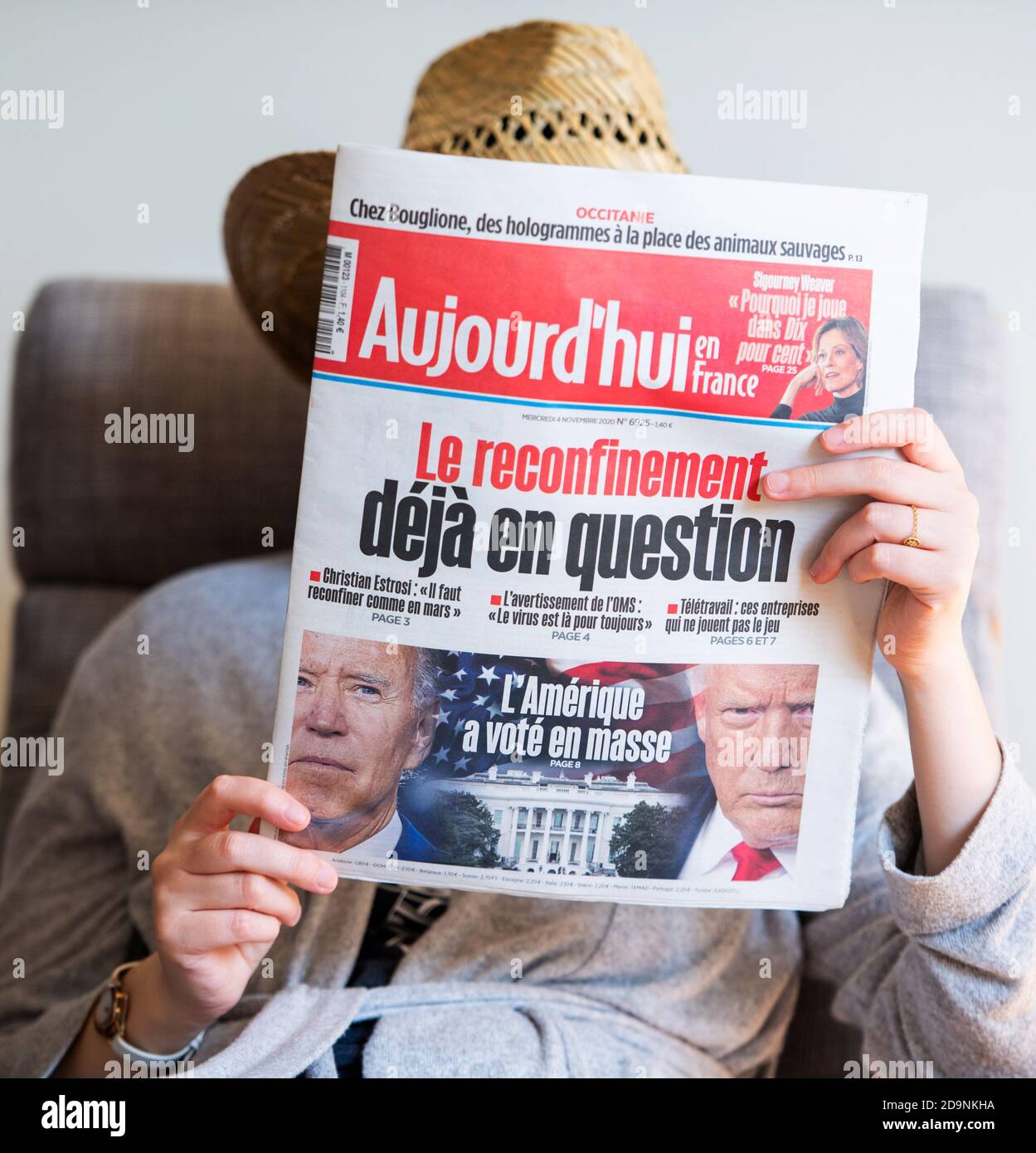 Paris, Frankreich - 5. Nov 2020: Frau liest im Wohnzimmer die neueste Aujord'hui Zeitung, die auf dem Deckblatt den letzten Tag der Wahl für das US-Präsident Rennen zwischen Donald Trump und Joe Biden, demokratischer Kandidat, zeigt Stockfoto