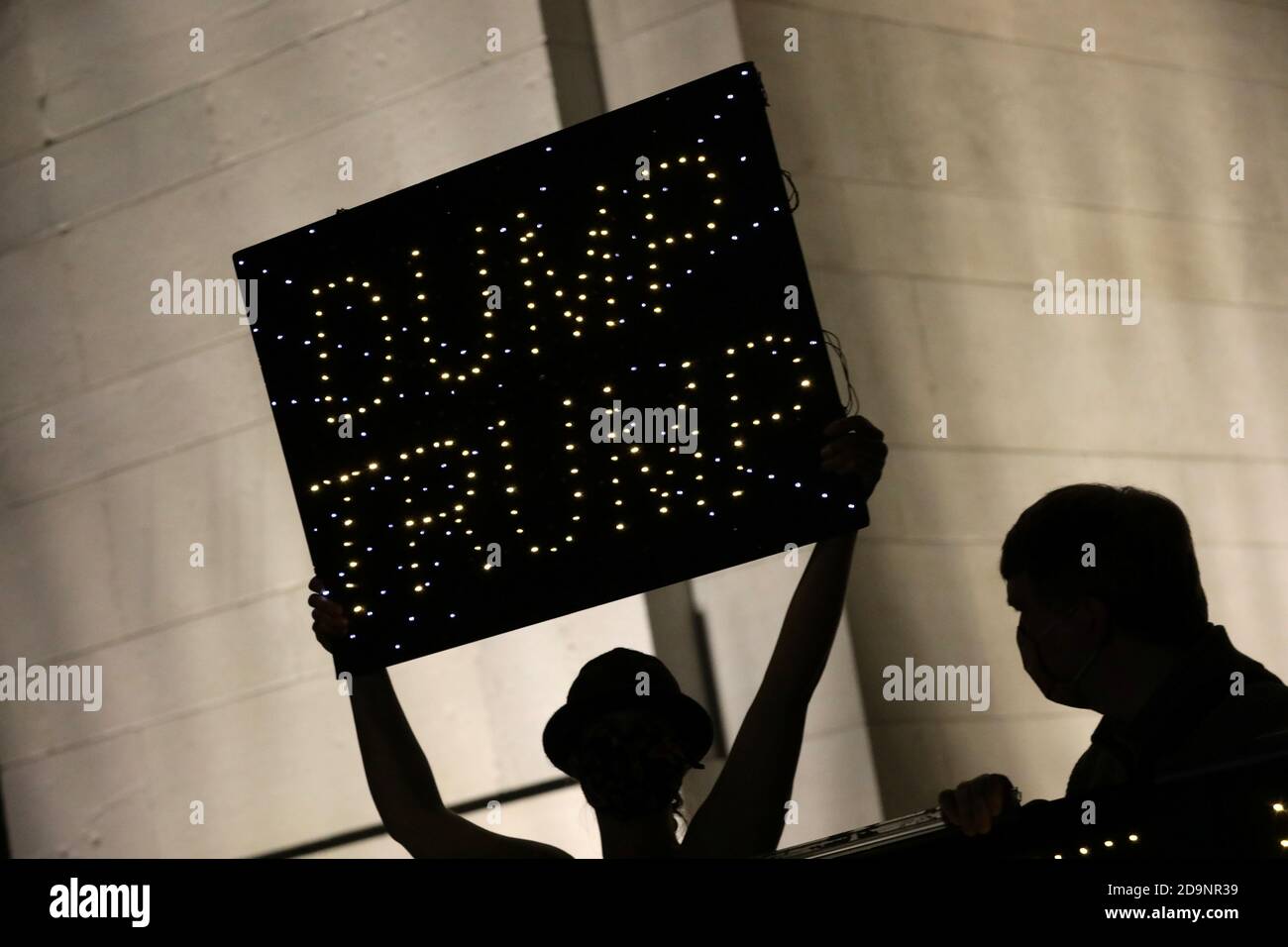 Eine Person trägt ein Schild mit der Aufschrift "Dump Trump" im Washington Square Park im Stadtteil Manhattan von New York City, USA, nach dem Wahltag, dem 6. November 2020. REUTERS/Jeenah Moon Stockfoto