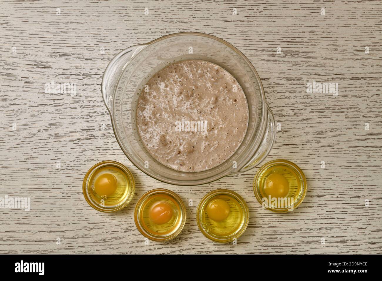 Der Prozess der Zugabe von Eiern zu fermentierten Hefe sprudeln in Milch. Stockfoto
