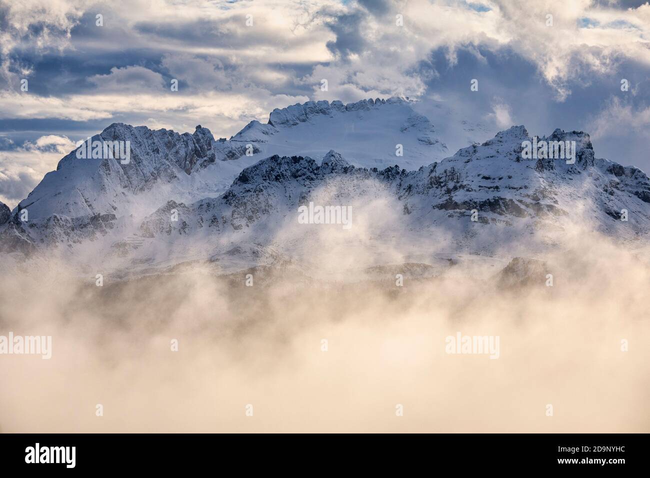 Der scharfe Grat von Padon und hinter der Marmolada umgeben von Wolken in einer Winterlandschaft, Dolomiten, Provinz Belluno, Venetien, Italien, Europa Stockfoto