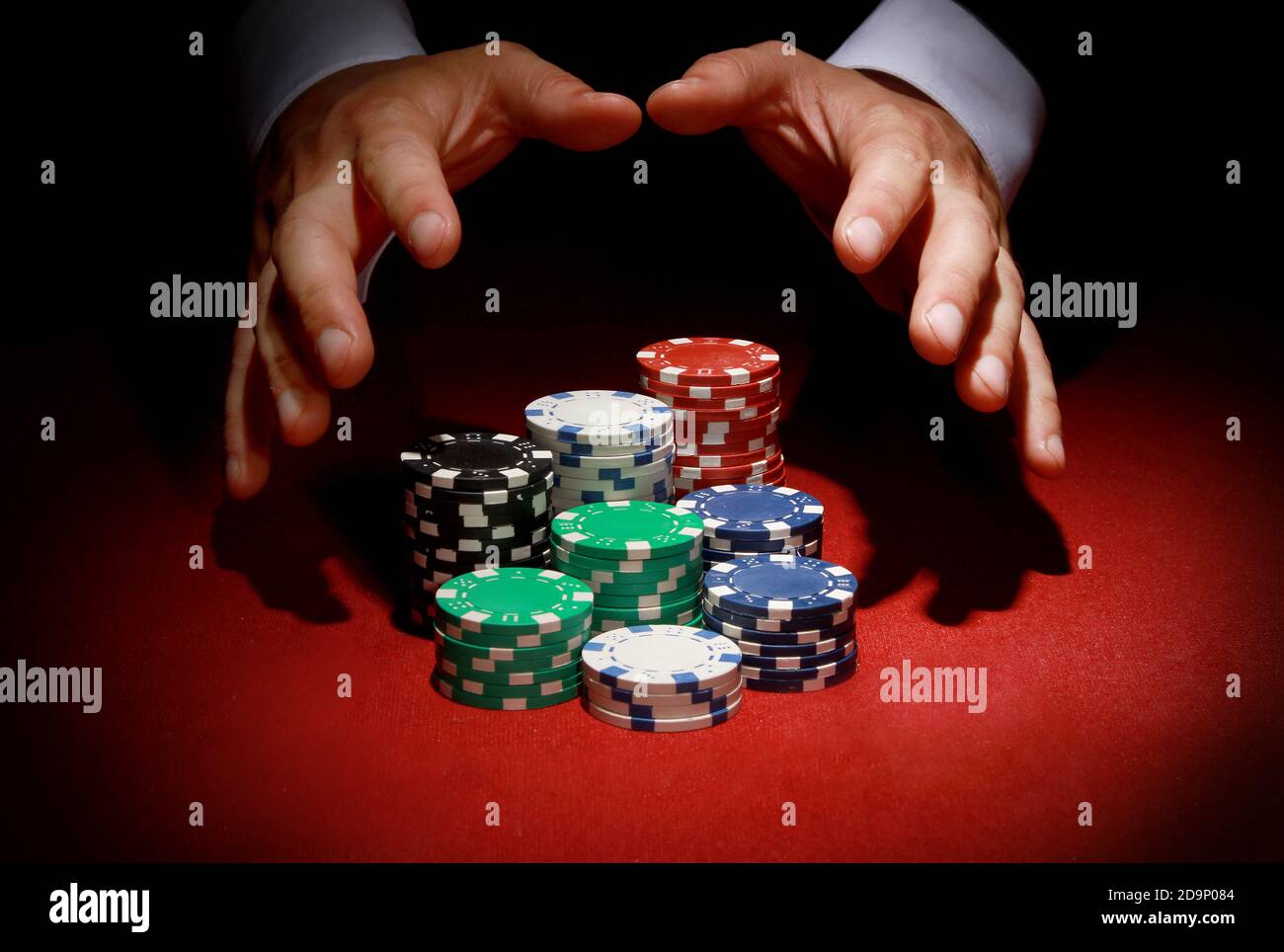 Ein Pokerspieler bewacht seine gewinnenden bunten Chips bei einem club Stockfoto