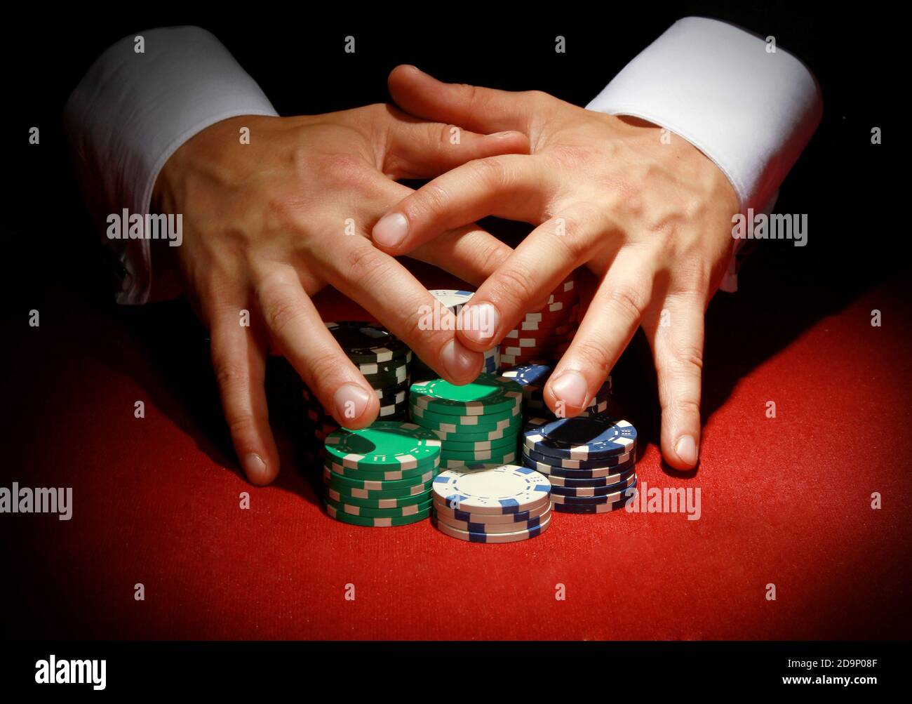 Ein Pokerspieler bewacht seine gewinnenden bunten Chips bei einem club Stockfoto