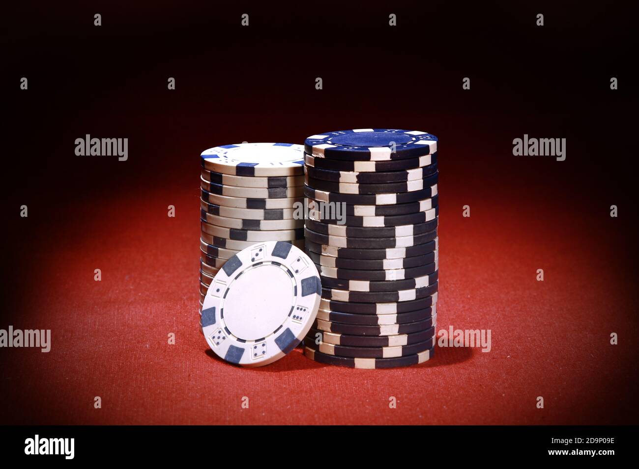 Die Stapel von blauen und weißen Pokerchips auf einem Roter Tisch Stockfoto
