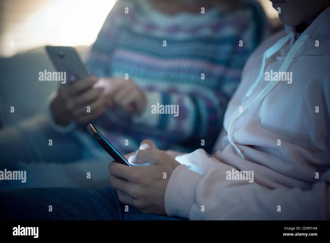 Konzept der Technologie und Online-Addiced Connected People zu Hause Mit unkenntlichen paar Messaging und Chat mit Smart Cellular - Blautöne Stockfoto
