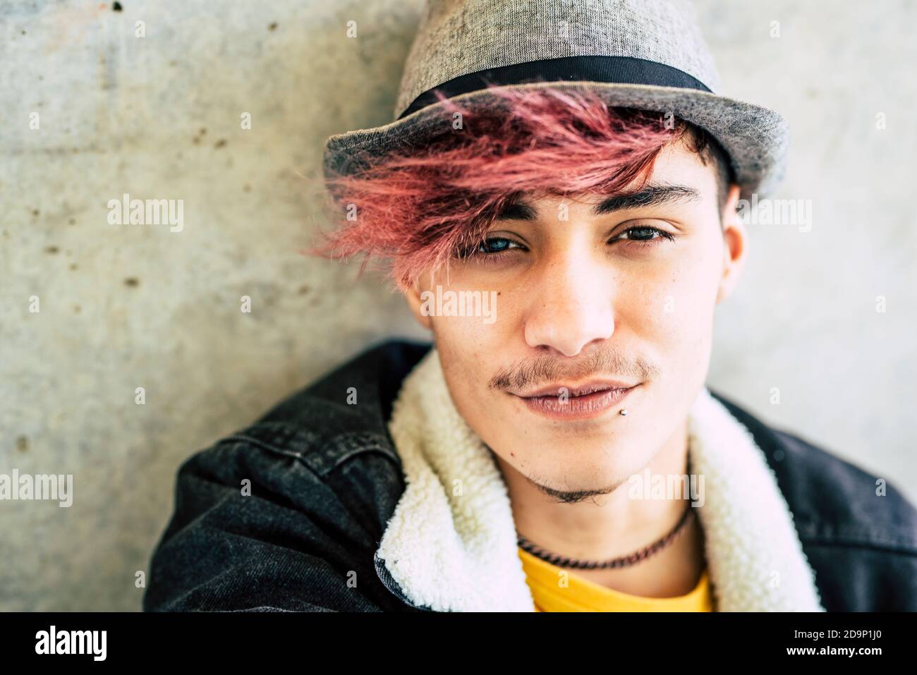 Porträt von schönen jungen Teenager männlichen Jungen Blick auf Kamera- - alternative Vielfalt aussehen violette Haare und Hut - Alter Student 17 Jahre alt schönen Mann Gesicht Stockfoto