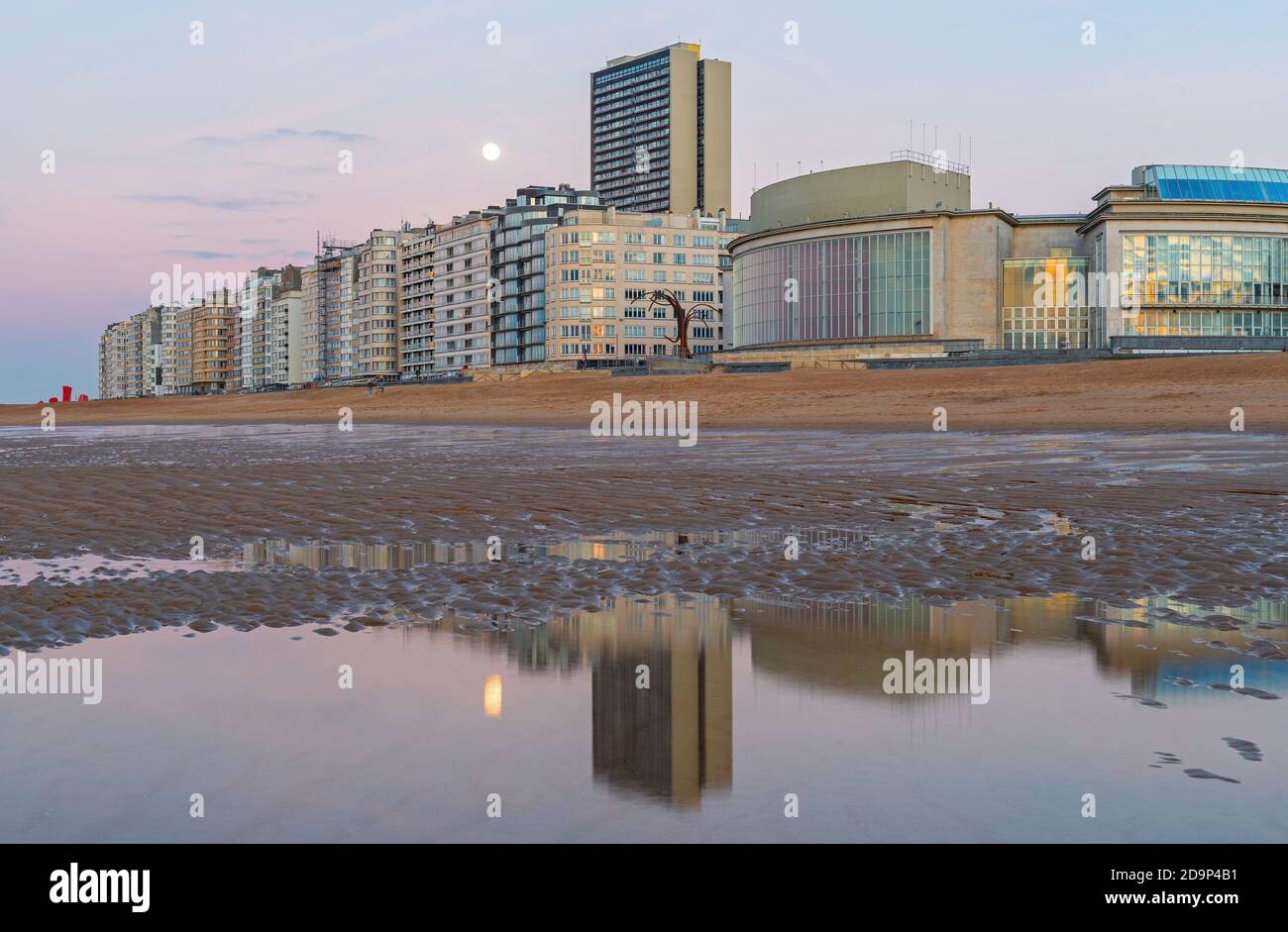 Skyline von Oostende (Oostende) mit Nordseestrand bei Sonnenuntergang und Vollmondspiegelung, Belgien. Stockfoto