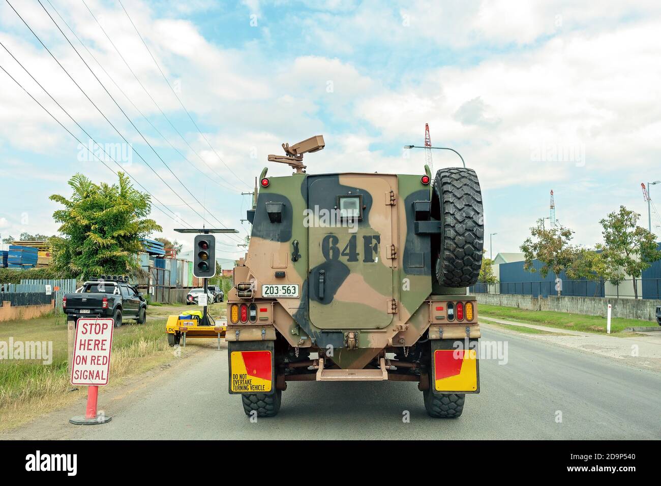 Brisbane, Queensland, Australien - 26. September 2019: Gepanzerter Militärtruppentransporter an einem Autobahnstop-Schild Stockfoto