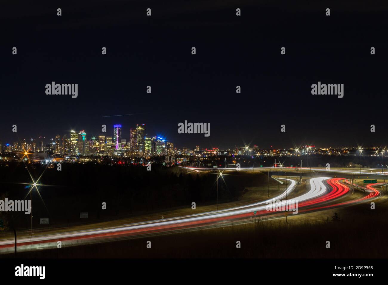 Calgary Alberta Skyline bei Nacht mit Deerfoot Trail im Vordergrund Stockfoto