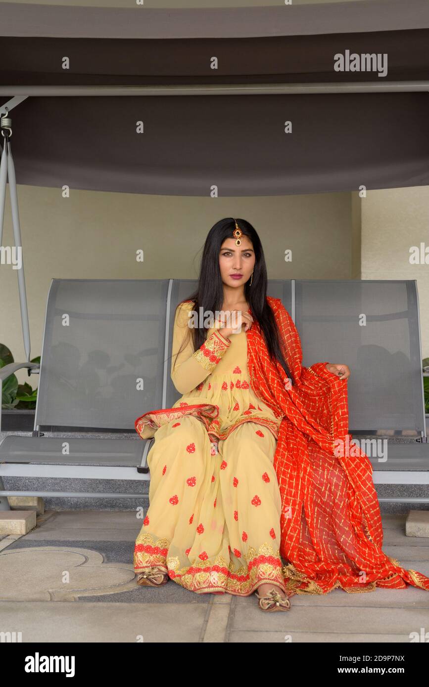 Junge Frau trägt traditionelle indische Kleidung während des Sitzens Stockfoto