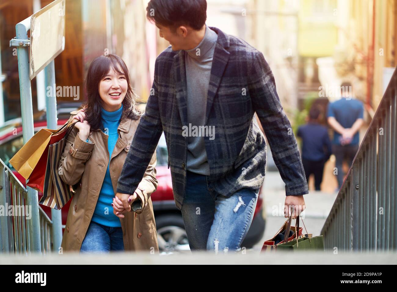 Glücklich junge asiatische Paar zu Fuß sprechen Hände halten beim Einkaufen In der Stadt Stockfoto