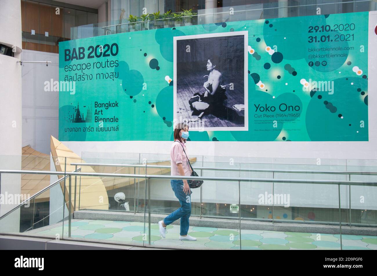 Bangkok, Thailand. November 2020. Eine Frau mit Gesichtsmaske geht an einem großen Schild der "Bangkok Art Biennale 2020" im Bangkok Art and Culture Centre (BACC) vorbei.Bangkok Art Biennale (BAB) ist ein halbjährliches Kunstfestival, das in der Hauptstadt Thailands im Herzen von Bangkok stattfindet, in Galerien, öffentlichen Räumen, Tempel und ikonischen Wahrzeichen. Bangkok Art Biennale (BAB) wurde vom 29. Oktober 2020 bis zum 31. Januar 2021 begonnen. Kredit: SOPA Images Limited/Alamy Live Nachrichten Stockfoto