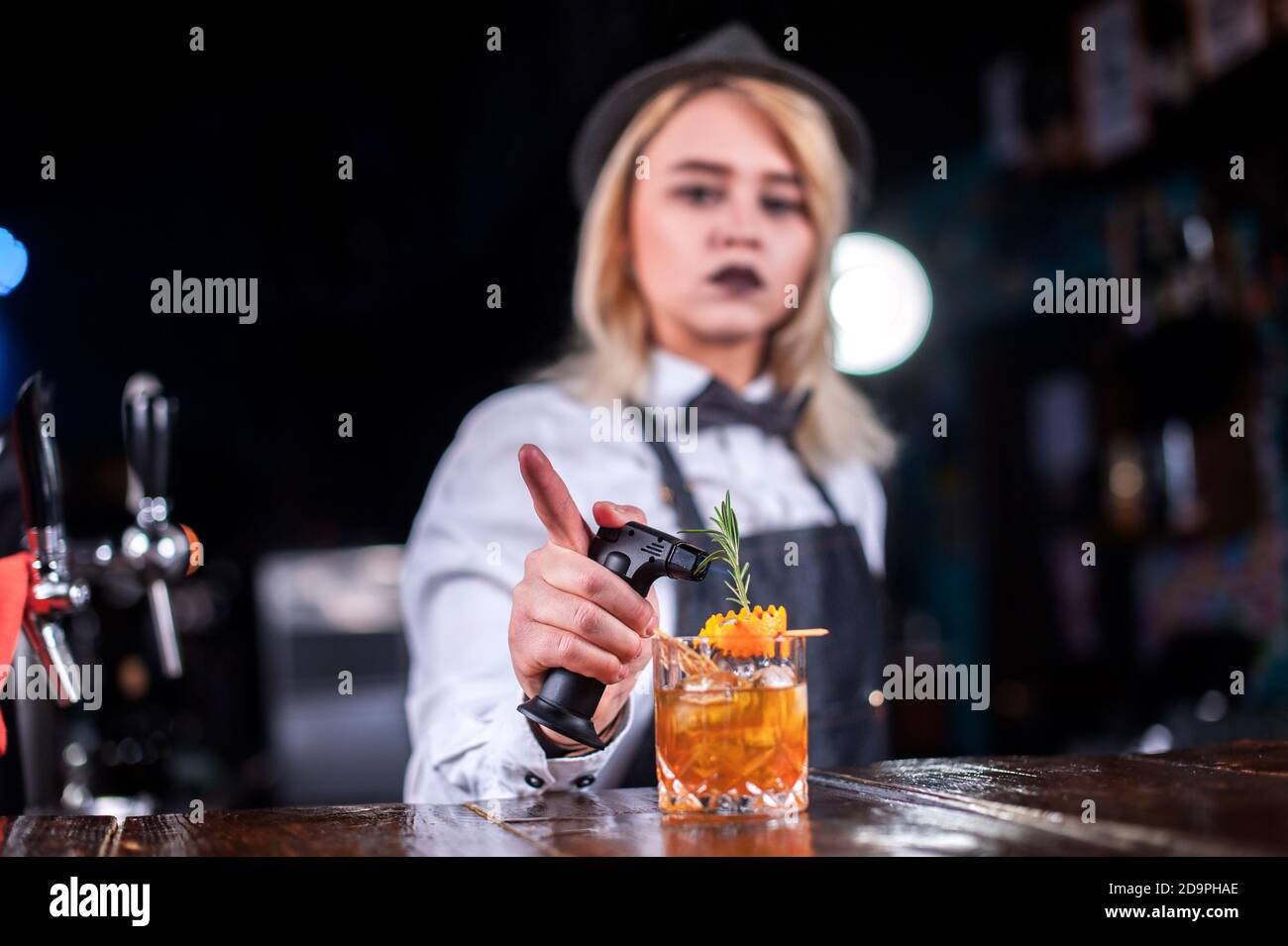 Fokussierte Frau Barkeeper macht eine Show erstellen einen Cocktail, während In der Nähe der Theke im Pub Stockfoto
