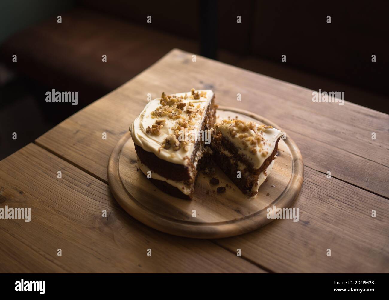 Karottenkuchen auf Couchtisch im Café. Holzbrett mit Kuchen auf. Stockfoto