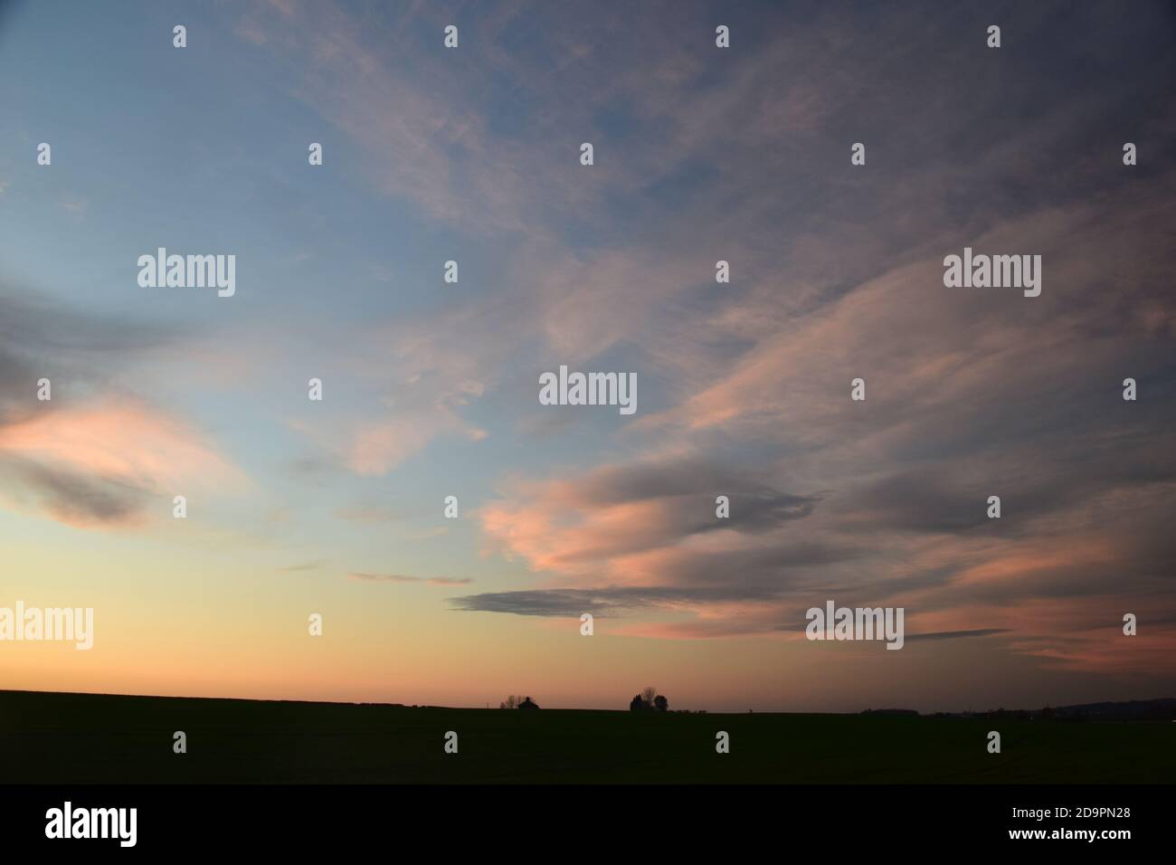 Cirrus-Art Wolken mit Farbe von der untergehenden Sonne getönt Hervorhebung Formen und Muster über den Himmel. Stockfoto