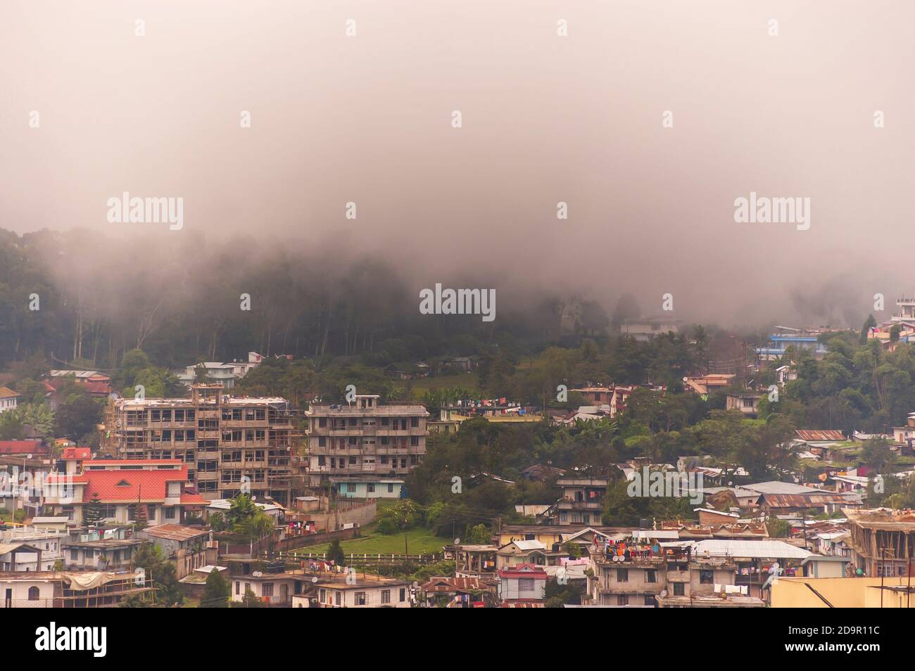 Nebel rollt in die Stadt Shillong in Meghalaya, Indien, von der anderen Seite des Berges nach einem Gewitter am Nachmittag während der Monsunsaison. Stockfoto