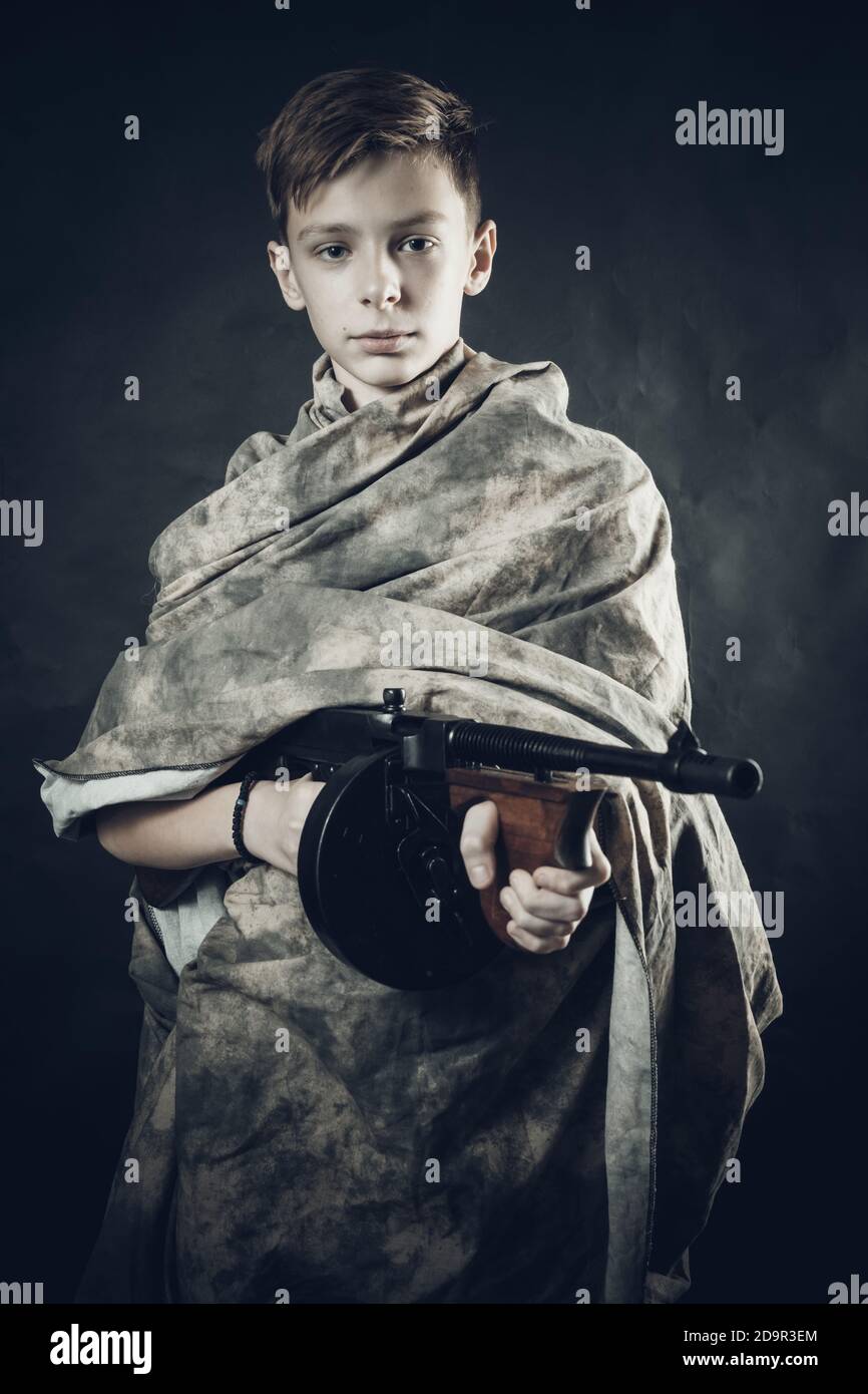 Tenn Junge in Tarnmantel mit einer Waffe spielen gekleidet Soldier Studio Portrait Stockfoto