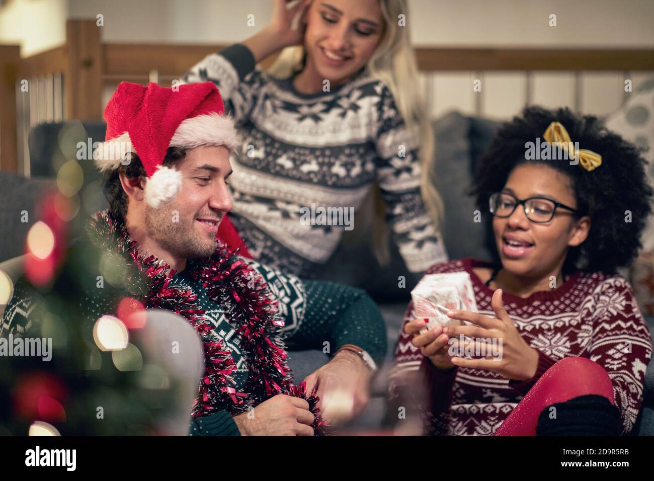 Gruppe von Freunden in Santa hat Austausch Weihnachtsgeschenke zusammen; Home Xmas Feier Konzept Stockfoto