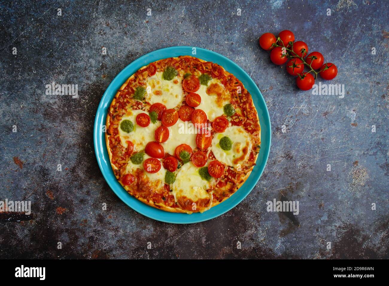 Hausgemachte Pizza mit Tomaten, Mozzarella-Käse und Basilikum-Pesto. Stockfoto