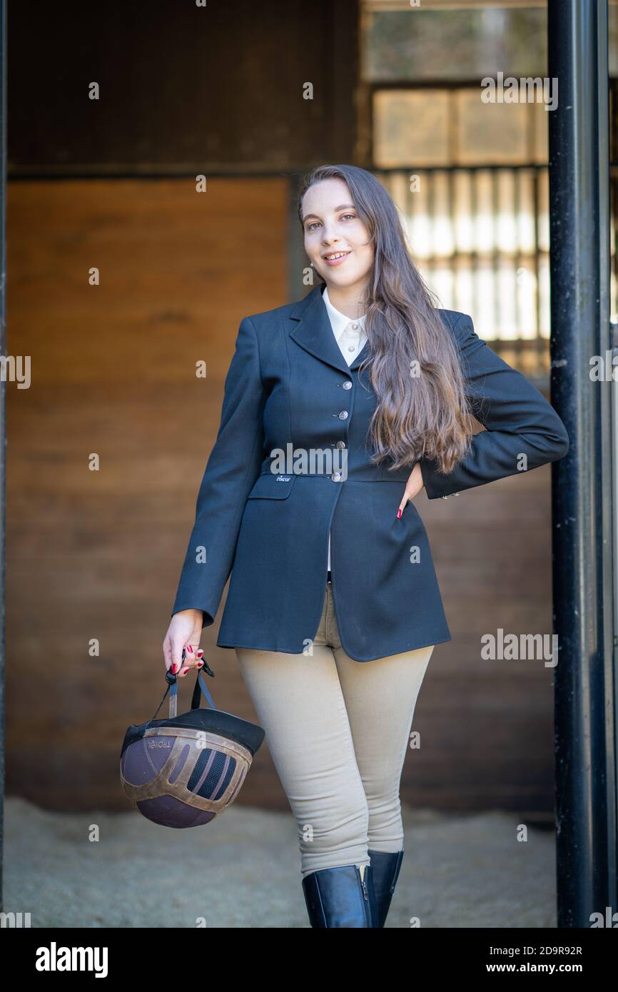 Reiterin Frau in englisch Reiten vor Stalltür stehend gekleidet Stockfoto