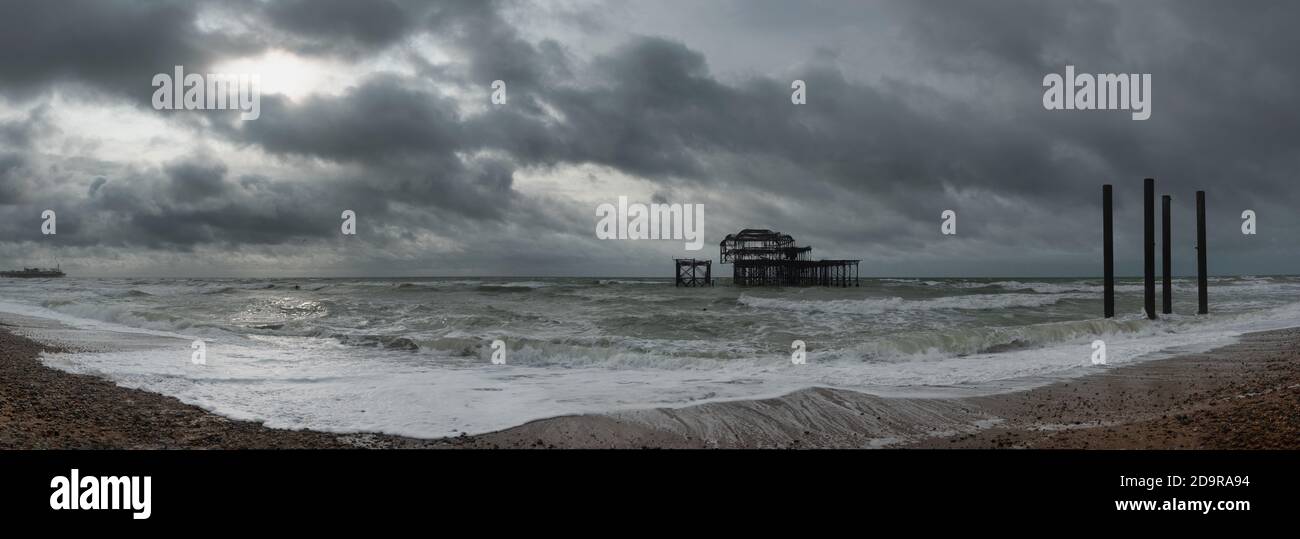 Brighton's steinige Strandlandschaft und West Pier Ruinen, England Stockfoto