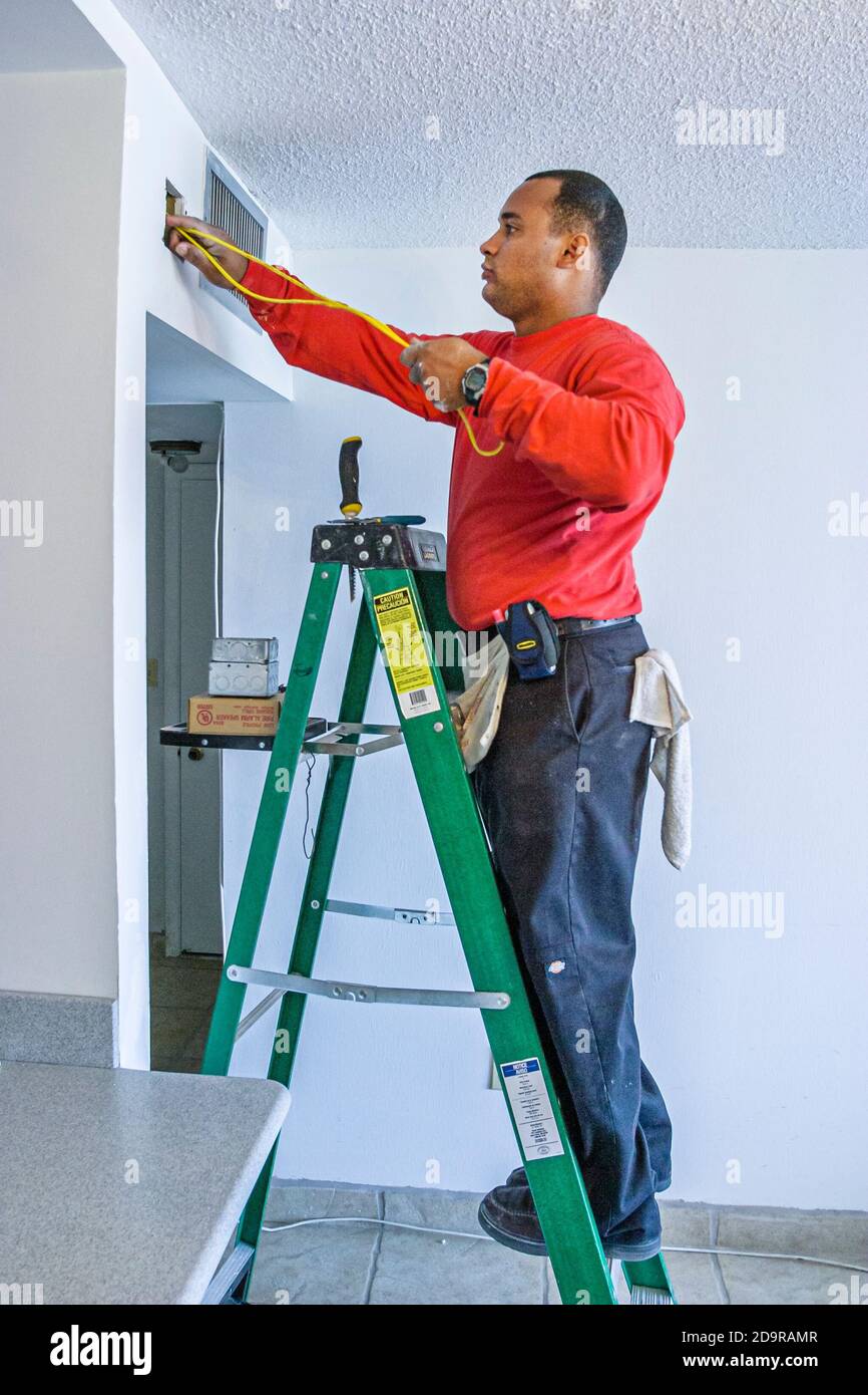 Miami Beach Florida, Wohnanlage, hispanischer Einwanderer Mann Männer männlich, Feueralarm Installateure arbeiten Installation Leiter, Stockfoto