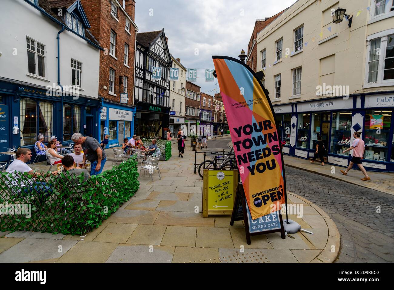 Schild, auf dem steht, dass Ihre Stadt Sie in Shrewsbury High Street, Shropshire, West Midlands vor einem leeren Einkaufszentrum braucht Stockfoto