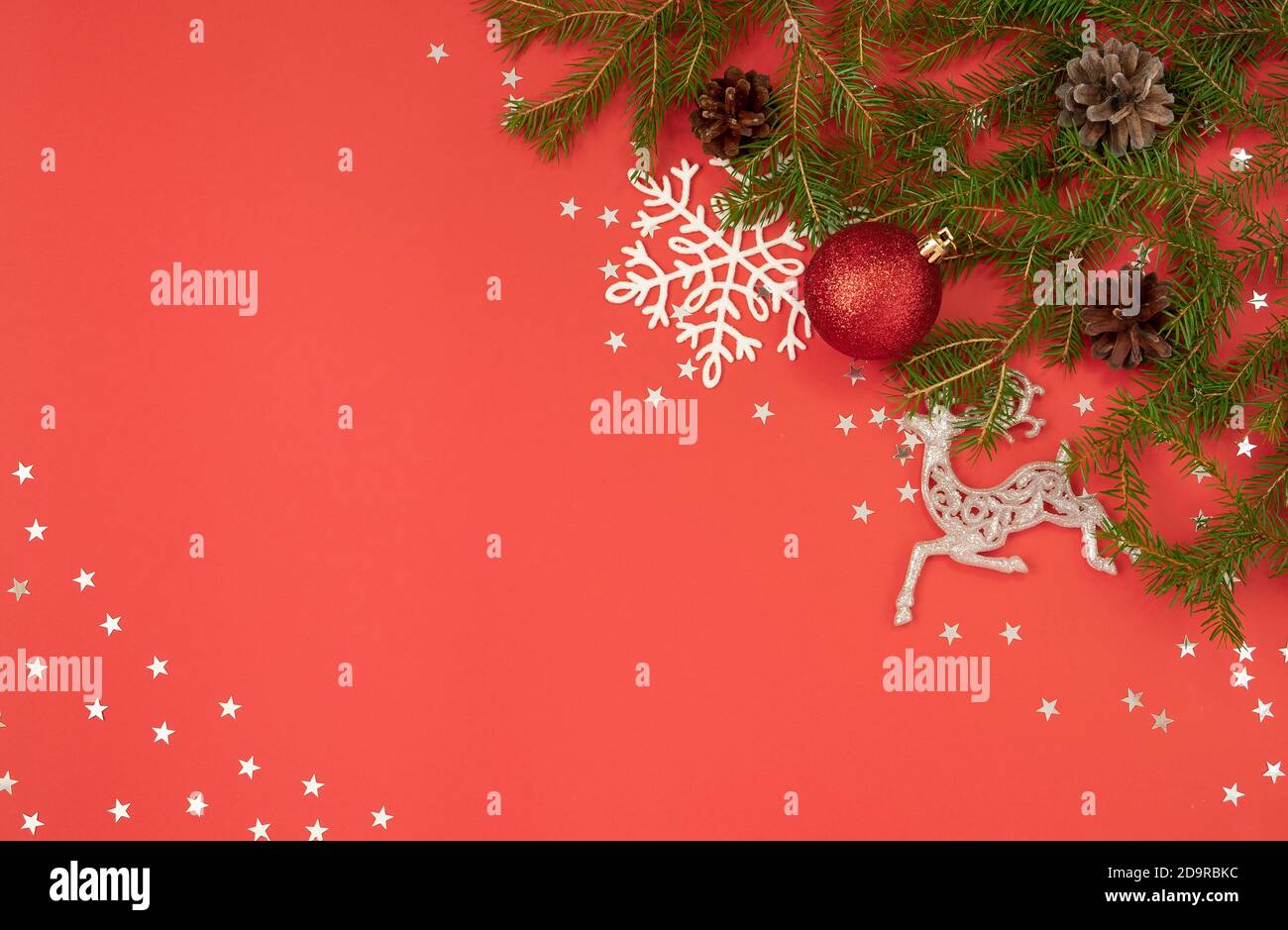 Weihnachtliche Hintergrund mit Tannenzweigen und festlichen Dekor auf einem Heller roter Hintergrund Stockfoto