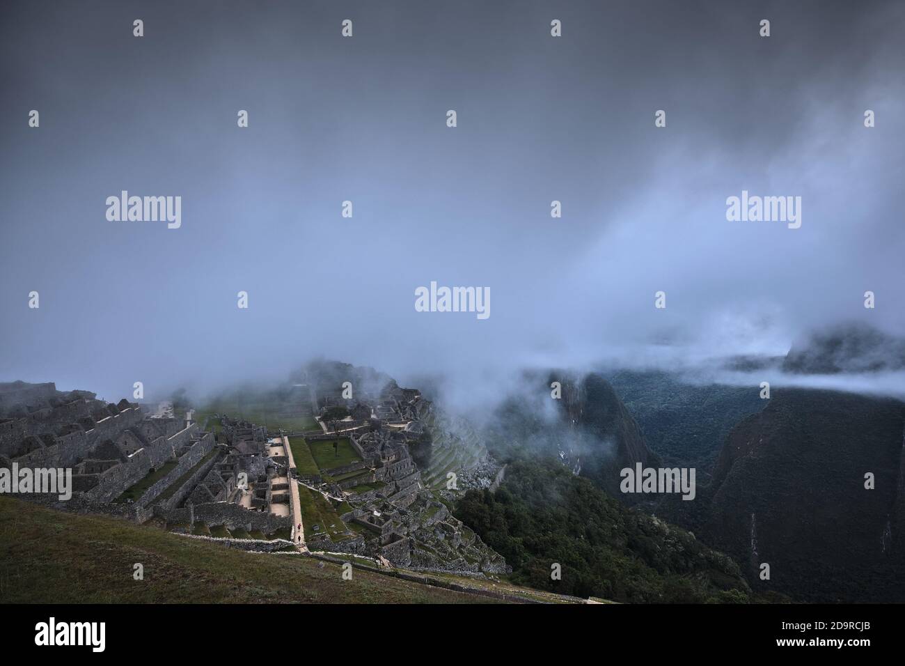 Sonnenaufgang Morgendämmerung: Nebel und niedrige Wolke über den Ruinen von Machu Picchu, Peru Stockfoto