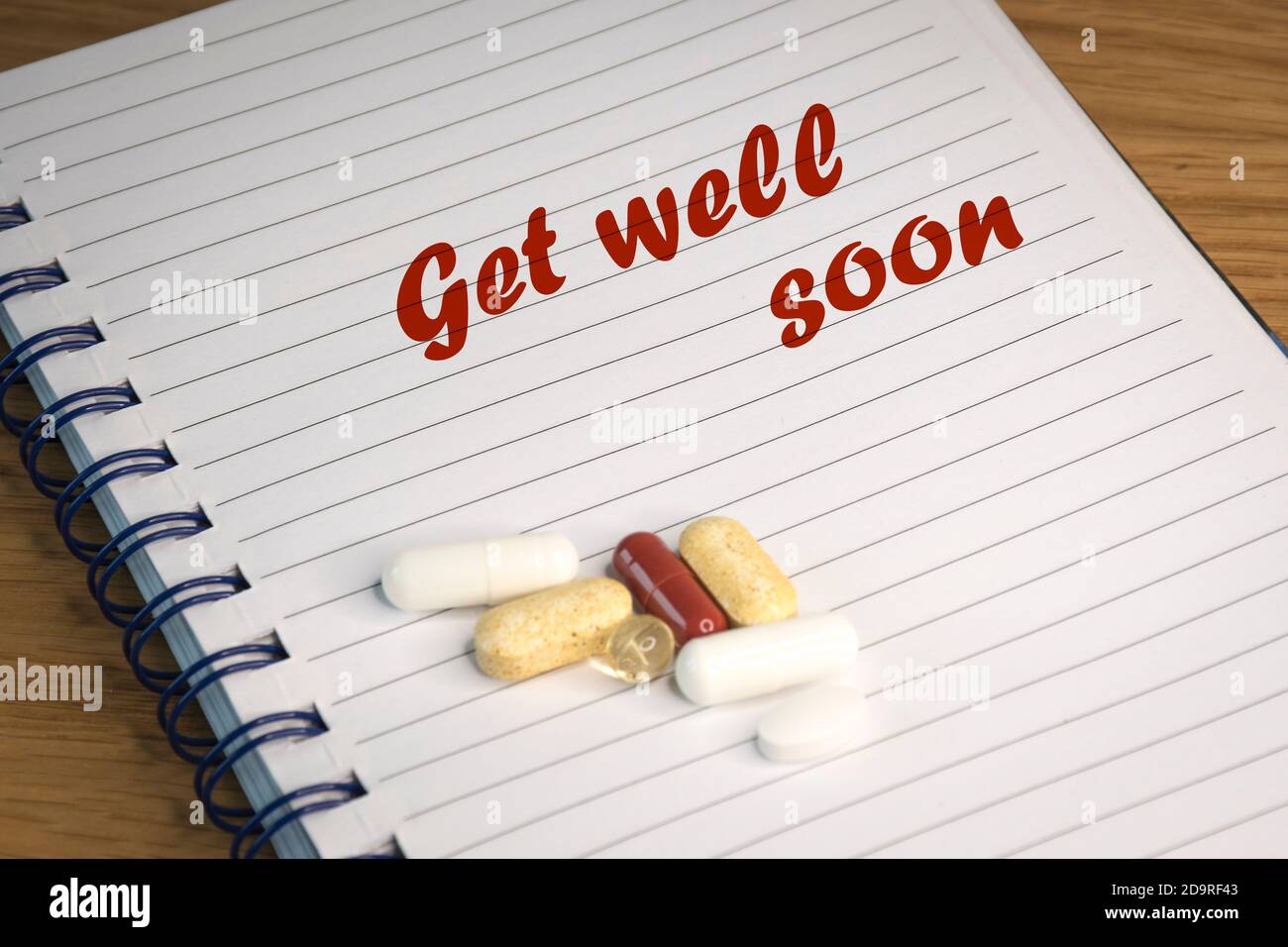 Englischer Text 'Get well soon' inspiriert von den weltweiten Coronavirus-Pandemien. Der Text ist auf liniertem Papier geschrieben. Stockfoto
