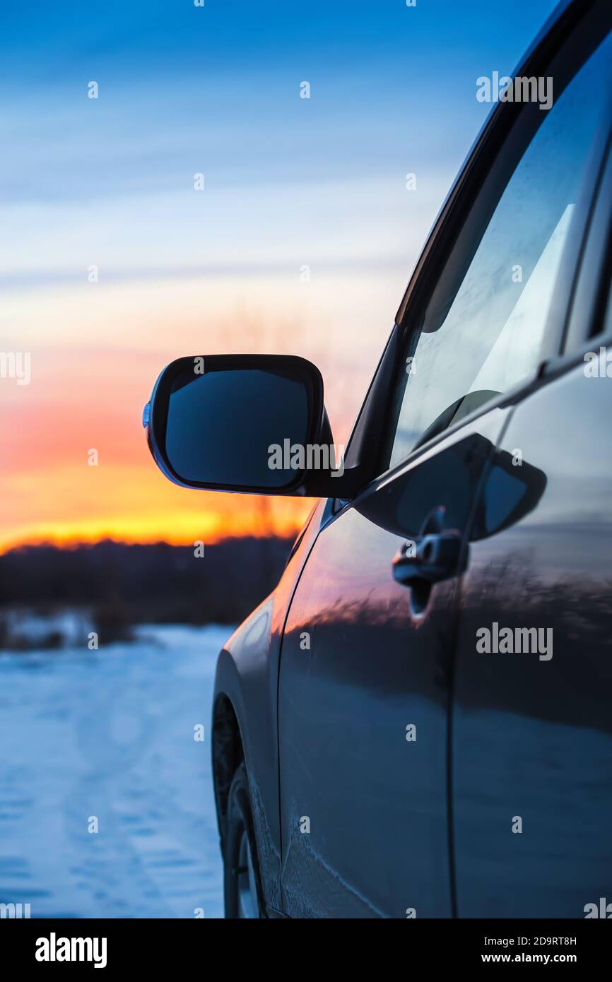 Auto auf einer verschneiten Straße bewegt sich bei Sonnenuntergang Stockfoto