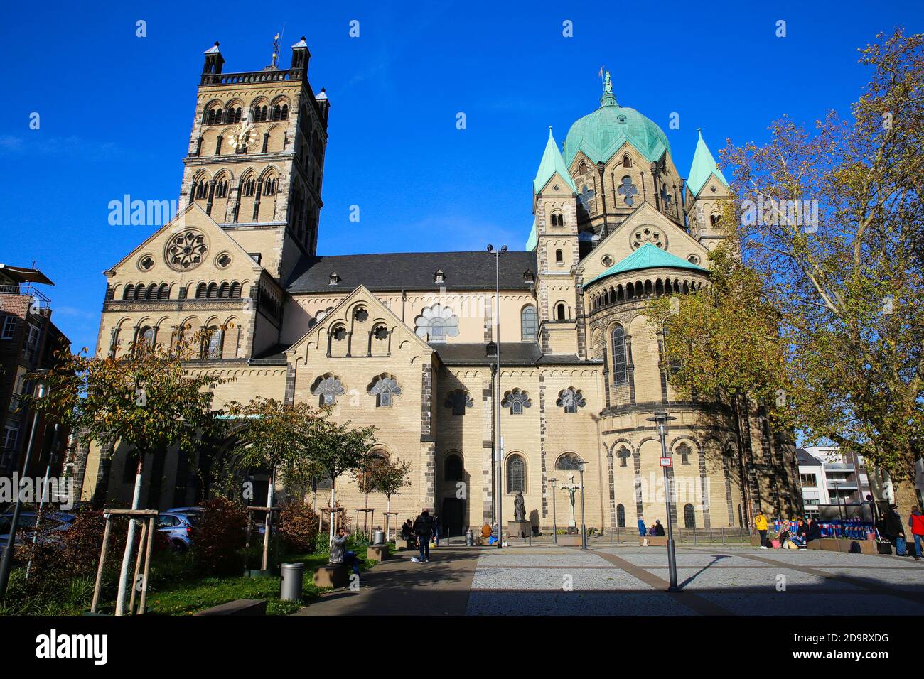 Neuss, Deutschland - 7. November. 2020: Blick über den Platz auf die römisch-katholische Basilika Quirinus mit Bäumen in Herbstfarben Stockfoto