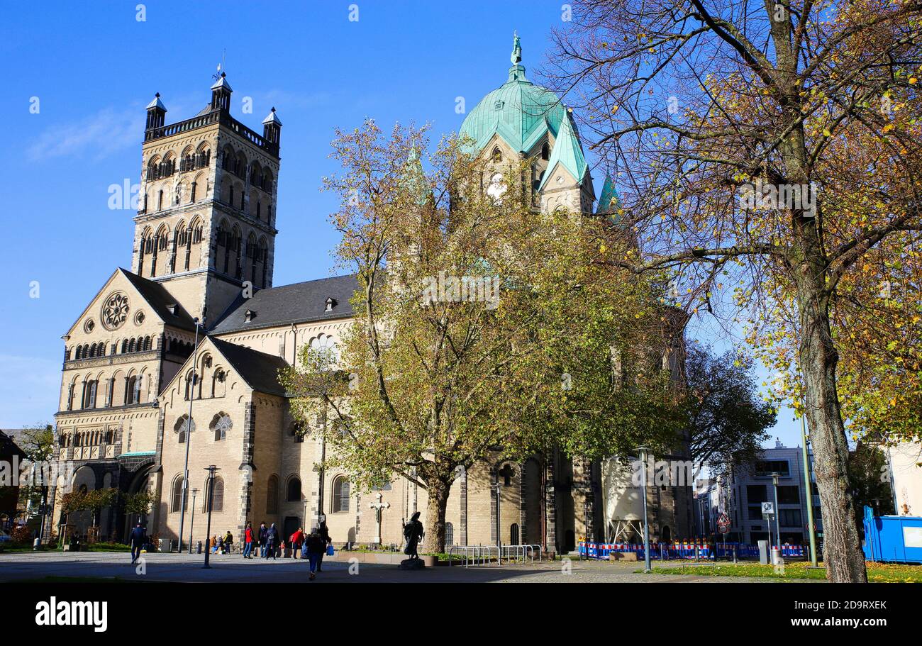 Neuss, Deutschland - 7. November. 2020: Blick über den Platz auf die römisch-katholische Basilika Quirinus mit Bäumen in Herbstfarben Stockfoto