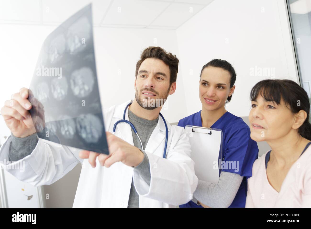 Arzt Krankenschwester und weibliche Patientin im Büro suchen eine Röntgenaufnahme Stockfoto